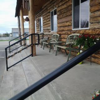 A log cabin porch with metal railings and outdoor seating.