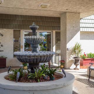 A tiered fountain surrounded by plants in a courtyard setting.