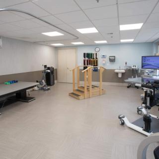 A well-equipped rehabilitation room featuring therapy tables and exercise equipment for physical therapy.