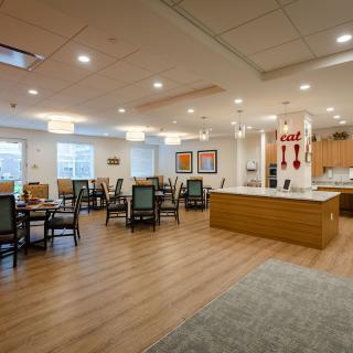 A spacious and modern dining area with wooden flooring and ample seating.