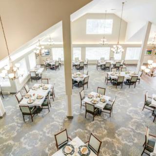 An elegant and spacious dining room with neatly arranged tables and chairs.