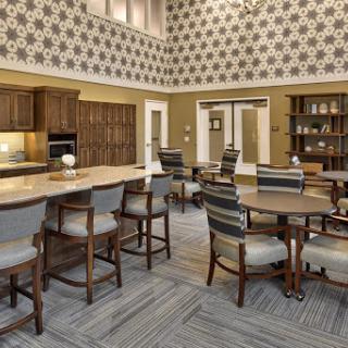A modern common area featuring a kitchen and dining space, designed with stylish furniture and decorative walls.
