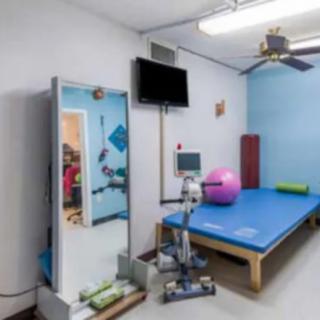 A physical therapy room equipped with various exercise tools, including a therapy mat and balance ball.