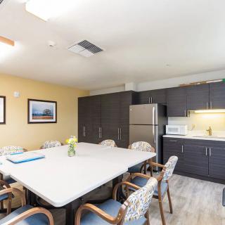 A modern kitchen and dining area with a large table, chairs, and appliances.