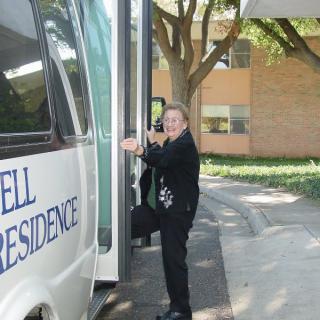 A person boarding a bus outside a building.