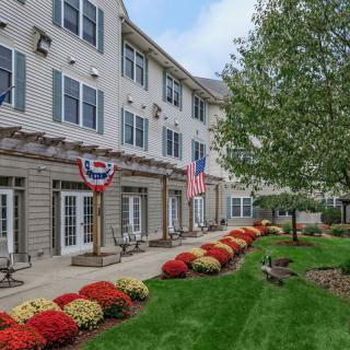 A well-maintained building with decorative flags and a landscaped garden.