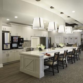 A modern kitchen with a large central island and stylish pendant lighting.