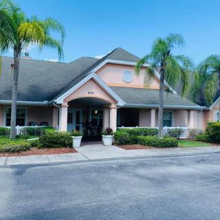 A suburban house with palm trees and a driveway.