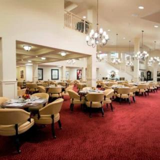 A spacious dining area with elegant chandeliers and comfortable seating.