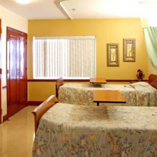 A hospital room with twin beds and medical equipment.