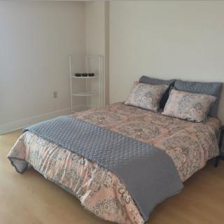 A minimalist bedroom with a neatly made bed and simple decor.