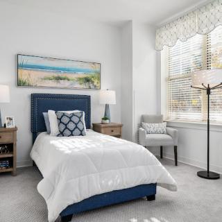 A cozy bedroom with a single bed, stylish decor, and ample natural light.