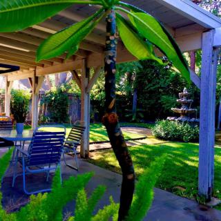 A serene garden patio with lush greenery and outdoor seating.
