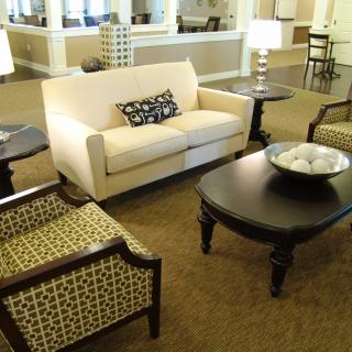 A cozy living room with a sofa, patterned chairs, and a coffee table.