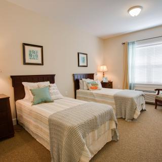 A cozy bedroom with twin beds and a bright window.