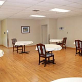 An empty dining area with tables and chairs on a hardwood floor.
