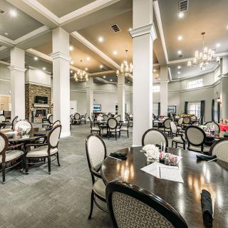An elegant dining area with tables and chandeliers in a spacious restaurant setting.