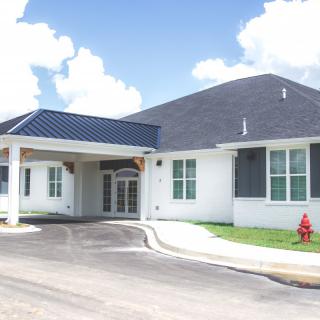 A modern residential building with a driveway and covered entrance.