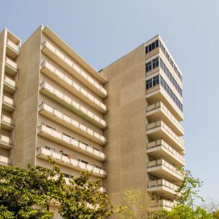 A modern apartment building with multiple balconies under a clear sky.