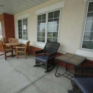 A cozy outdoor porch with seating and tables.