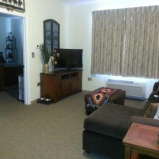 A cozy living room with a comfortable sofa, television, and well-arranged furniture.