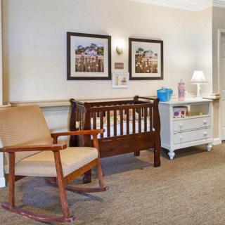 A cozy nursery room with a crib, rocking chair, and dresser.