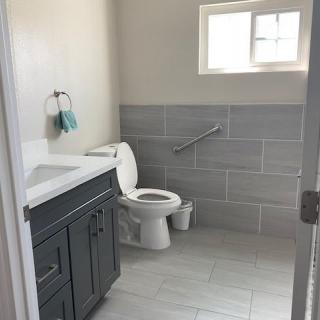 A clean and bright bathroom with a toilet, sink, and towel rack.