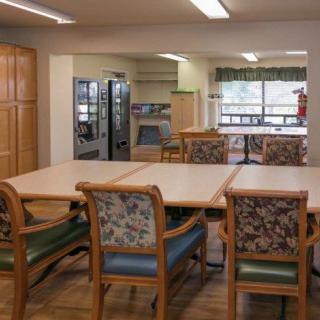 A communal dining area with tables and chairs, featuring a cozy and inviting atmosphere.