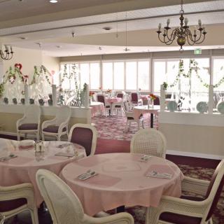 An elegant restaurant dining room with pastel colors and classic furnishings.
