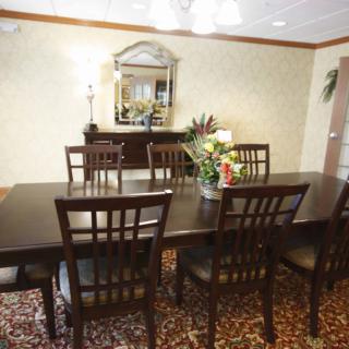 A well-decorated dining room with a large table, chairs, and a mirror on the wall.
