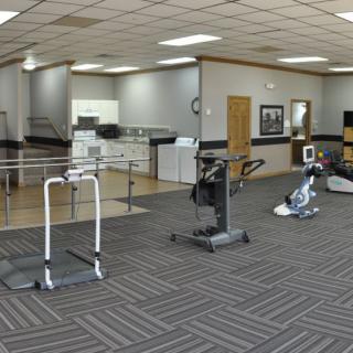 A physical therapy clinic featuring various exercise equipment for rehabilitation.