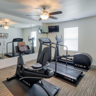 A small gym with exercise equipment including a treadmill and stationary bike.