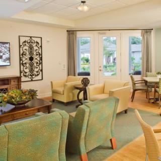A cozy living room with comfortable seating and large windows overlooking a garden.