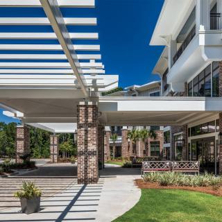 Modern architectural design featuring a pergola with brick pillars and open outdoor spaces.