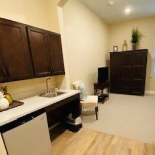 A compact kitchen area featuring dark cabinets, a sink, and minimalist decor.