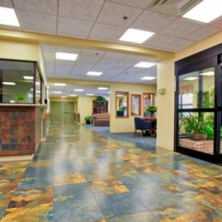 A spacious lobby with tiled flooring and a reception desk.