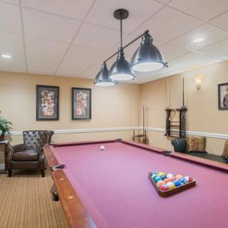 A cozy game room with a pool table, comfortable seating, and stylish decor.