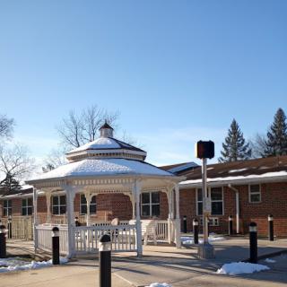 A picturesque gazebo covered in snow under a clear blue sky.