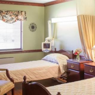 A hospital room with twin beds, adorned with curtains and a vase of flowers.