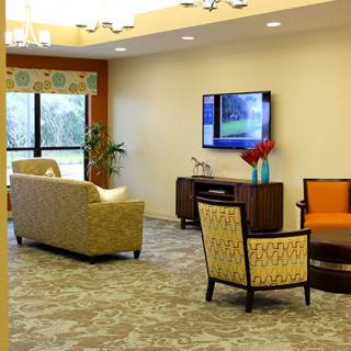 A modern living room with comfortable seating and a wall-mounted TV.