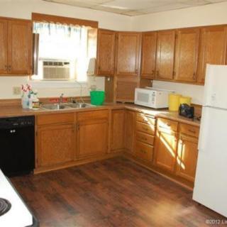 A cozy kitchen featuring wooden cabinets, a microwave, and a refrigerator.