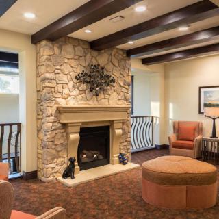 A cozy living room with a stone fireplace and comfortable seating.
