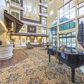A luxurious hotel lobby featuring a grand piano and elegant interior design.