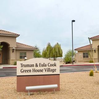 Entrance sign to the Truman & Eula Cook Green House Village with buildings and landscaping in the background.