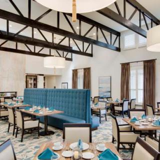 A modern dining area featuring spacious seating, blue accents, and stylish decor.