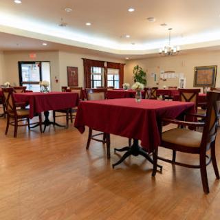 A cozy dining area with red tablecloths and wooden floors, ready for guests.