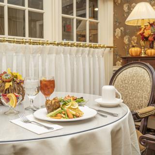 An elegantly set restaurant table with a meal and drinks, featuring tasteful decor.