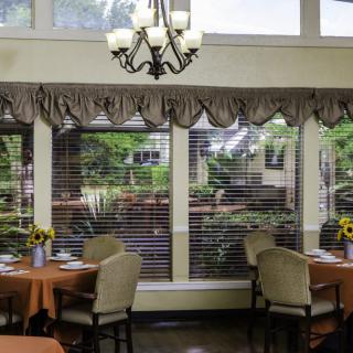A cozy dining room with large windows and elegant decor.