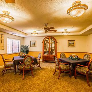 A warmly lit dining room with elegant furniture and decorative lighting.