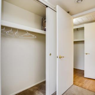 A spacious, empty closet with sliding doors and hanging space.